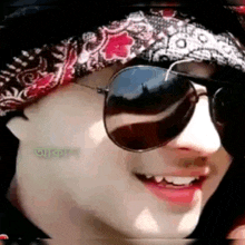 a close up of a person wearing sunglasses and a hat