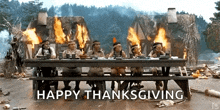 a group of native americans are sitting at a picnic table with fires behind them and the words happy thanksgiving on the bottom