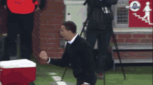 a man stands on a soccer field with his fist in the air and a sign that says bein sports