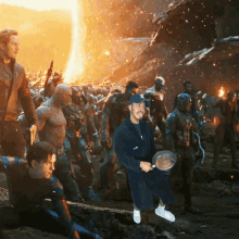 a man in a bathrobe holding a frying pan stands in front of a group of avengers