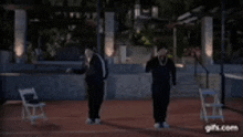 a couple of men are standing next to each other on a court .