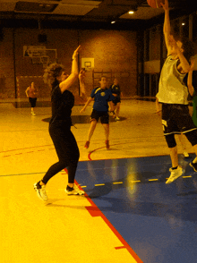 a basketball player wearing a jersey that says ' lg ' on it tries to block a shot