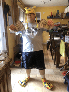 a man wearing a shirt that says mental illness holds a bunch of money in his hands