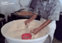 a man in a plaid shirt is mixing something in a large white bowl with live leak written on the bottom