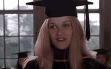 a woman in a graduation cap and gown is smiling .