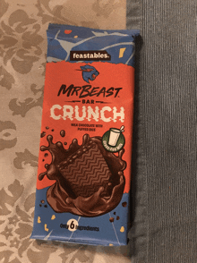 a package of mrbeast bar crunch lays on a bed