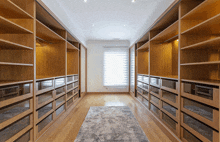 an empty walk in closet with lots of shelves and drawers