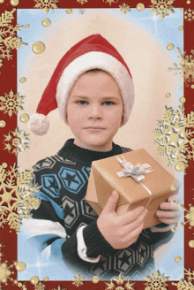 a young boy wearing a santa hat holds a gift box