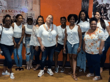 a group of women are posing for a picture in front of a poster that says fasismo