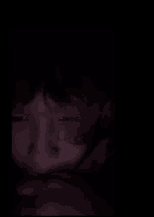 a close up of a person 's face with a dark background