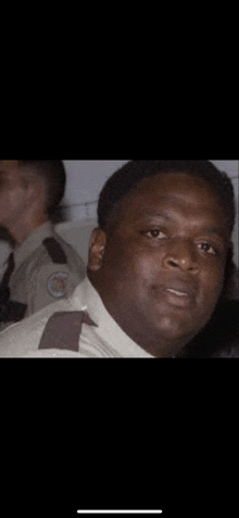 a man in a security uniform is smiling for the camera .