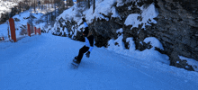 a person riding a snowboard down a snowy hillside