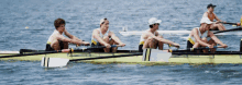 a group of men are rowing a boat with a sticker on the side that says ' sydney ' on it