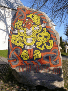 a large rock with a painting of jesus and a celtic design