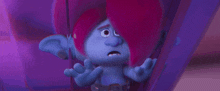 a troll with pink hair and blue ears is sitting in a purple room .