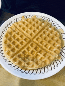 a waffle on a white plate with a black and white pattern