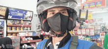 a man wearing a mask and a helmet is in a store with an oppo reno f