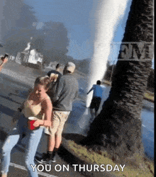 a group of people are standing in front of a water fountain with the words you on thursday below them