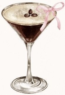 a martini glass filled with a drink and coffee beans with a pink bow .