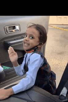 a little girl wearing headphones sits in a car