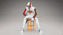 a man in a gucci hoodie is sitting on a wooden stool