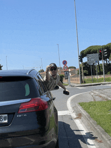 a man leans out of the window of a cdt s car