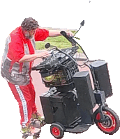 a man in a red shirt is standing next to a scooter with speakers on it