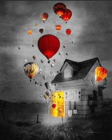 a black and white photo of a house with hot air balloons flying over it