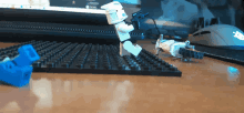 a lego storm trooper is standing on a table next to a keyboard and mouse