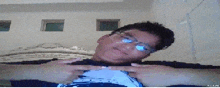 a pixelated image of a man wearing glasses with his hands on his chest