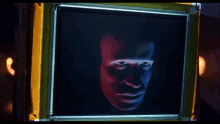 a man 's face is displayed on a screen