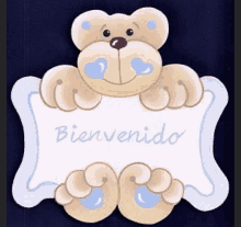 a teddy bear holding a sign that says bienvenido on it