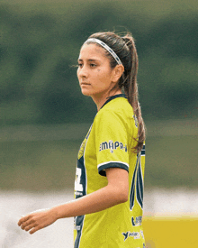 a female soccer player wearing a yellow jersey with the number 2 on the sleeve