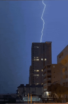 a lightning bolt strikes the top of a building at night