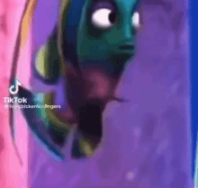 a fish from the movie finding nemo is swimming in a tank of water .