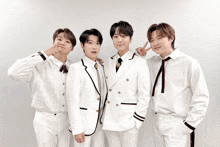 a group of young men wearing white suits and ties pose for a photo