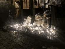 a group of statues are lit up with christmas lights and lanterns