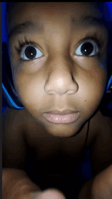 a close up of a young boy 's face with a blue background