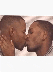 a couple of men are kissing each other on the cheek .