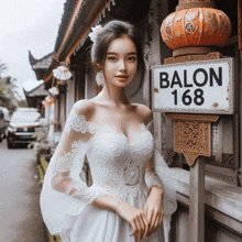 a woman in a wedding dress is standing next to a sign that says balon 168