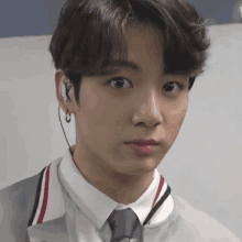 a close up of a young man wearing a suit and tie with earphones .