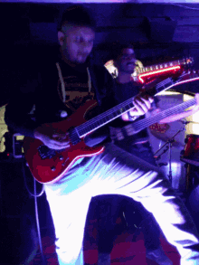 a man playing a guitar in a dark room with a shirt that says " i 'm not a fan " on it