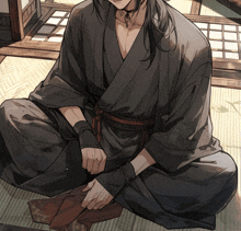 a man in a kimono sits on the floor with his hands tied