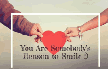 a man and a woman holding a red heart with the words " you are somebody 's reason to smile "