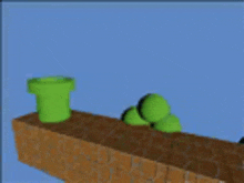 a green pipe is sitting on top of a brick wall next to a pile of green balls .