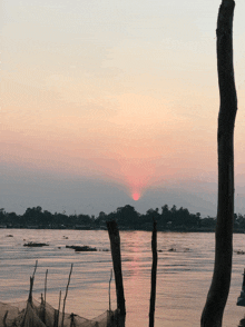 a sunset over a body of water with a few fishing nets in the foreground