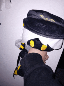 a person is wearing a black hat with yellow buttons