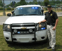 a police officer stands in front of a white chevrolet suv