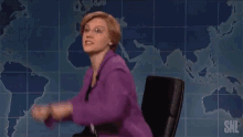 a woman in a purple jacket stands next to a man in a suit and tie on a snl show
