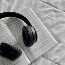 a pair of headphones laying on top of a book